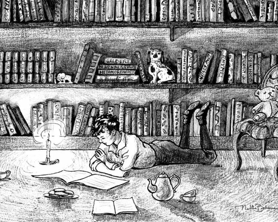 boy lying on floor reading books in library